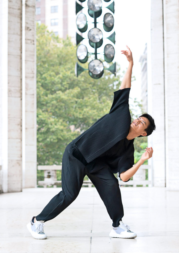 Chun Wai Chan reaches up while leaning over a lunge to the side on the balcony outside the Koch Theater