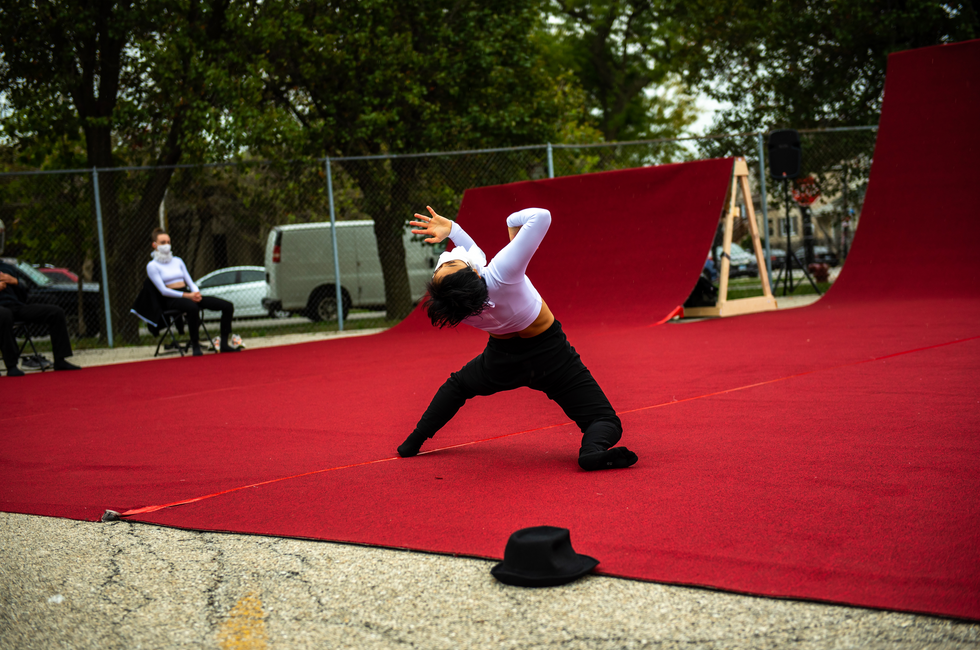 Ching Ching Wong bends backward on a red carpet outdoors.