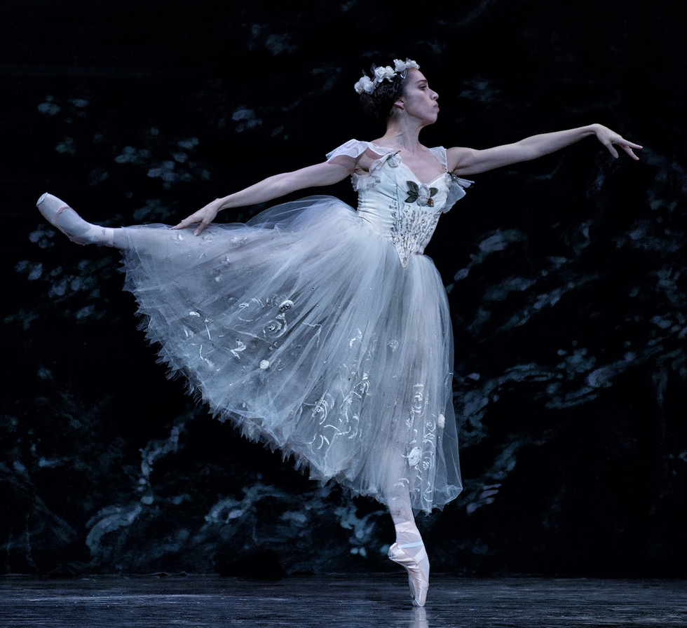 Jordana Duamec in an arabesque on pointe and translucent white tutu with a garland on her head