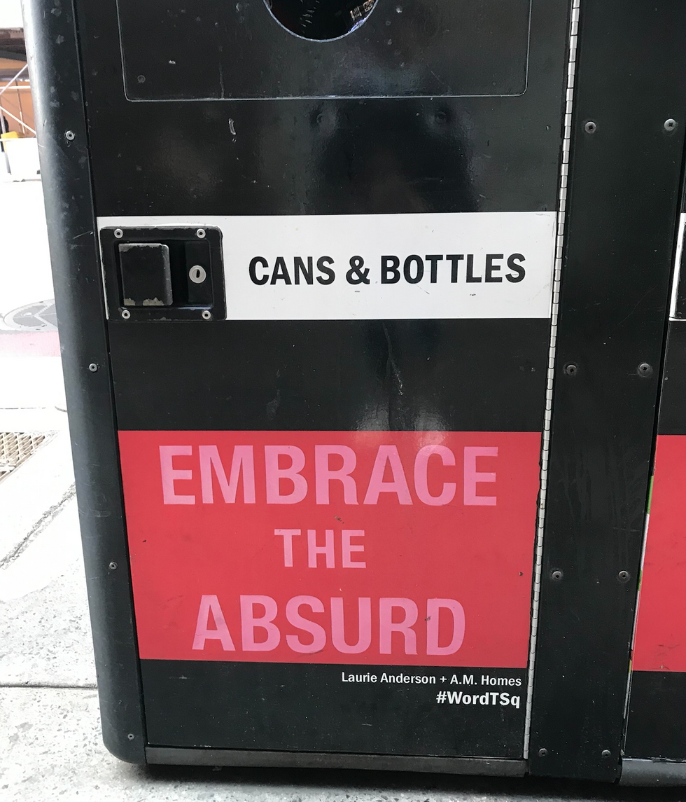 A trash can with a hole for cans and bottles shows the words Embrace the Absurd at the bottom