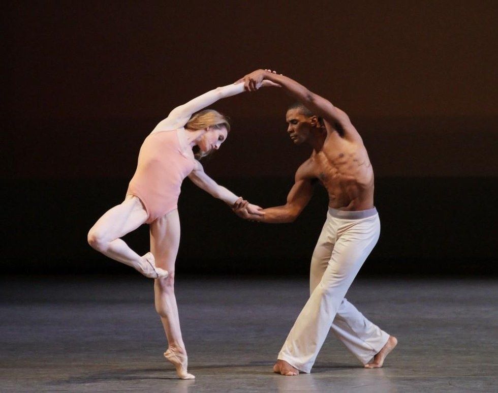 Wendy Whelan in passu00e9 wearing just a pale pink leotard holds the hands of Craig Hall and leans away