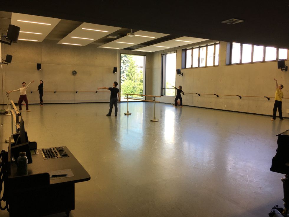 A ballet studio has just four dancers and a teacher, plus an open door.