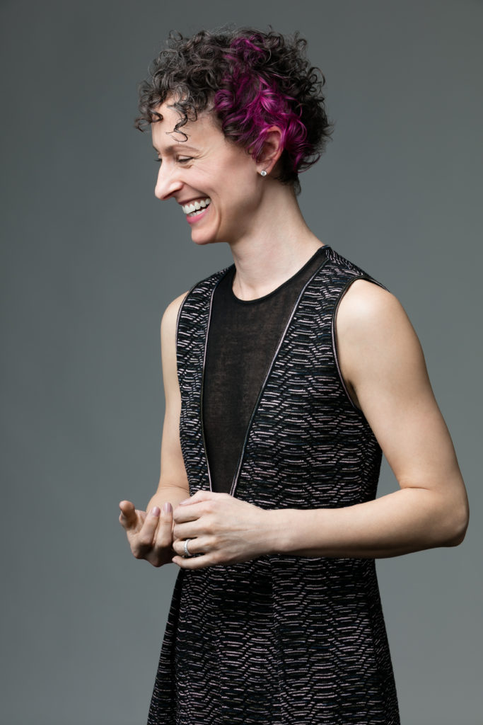 Woman with short curly hair wearing sleeveless black dress