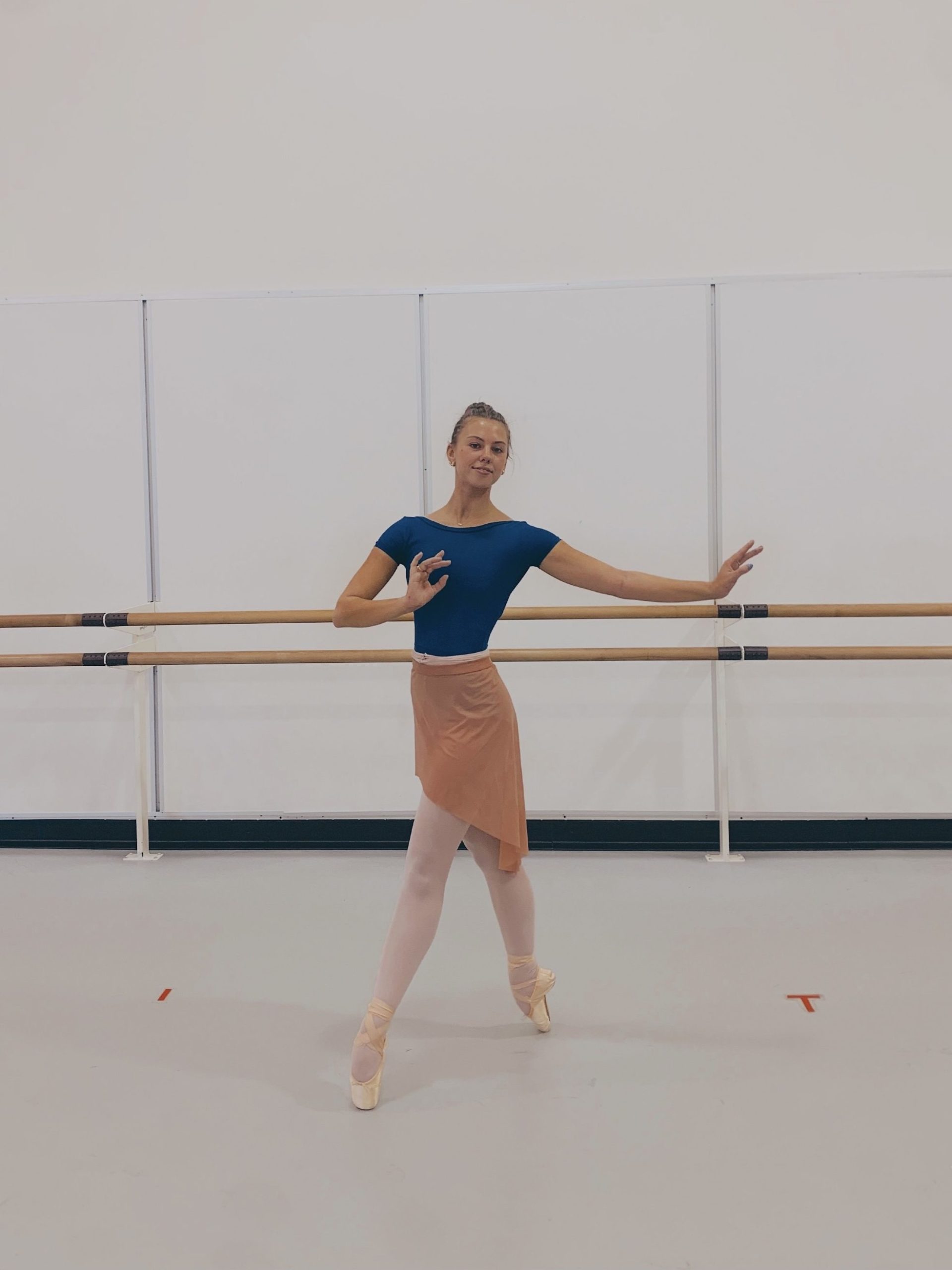 dancer in blue leotard, pink wrap skirt and pointe shoes