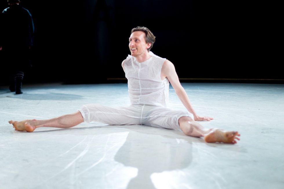 Reid Bartelme sits on the floor of the stage in costume, casually looking up and talking