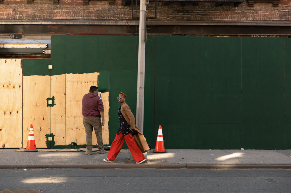 Martha Nichols walks in front of a boarded up storefront in New York