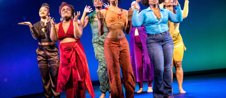 The cast of "for colored girls" are seven Black women, each costumed in a different color of the rainbow, and they stand facing the camera, dancing and singing in unison.