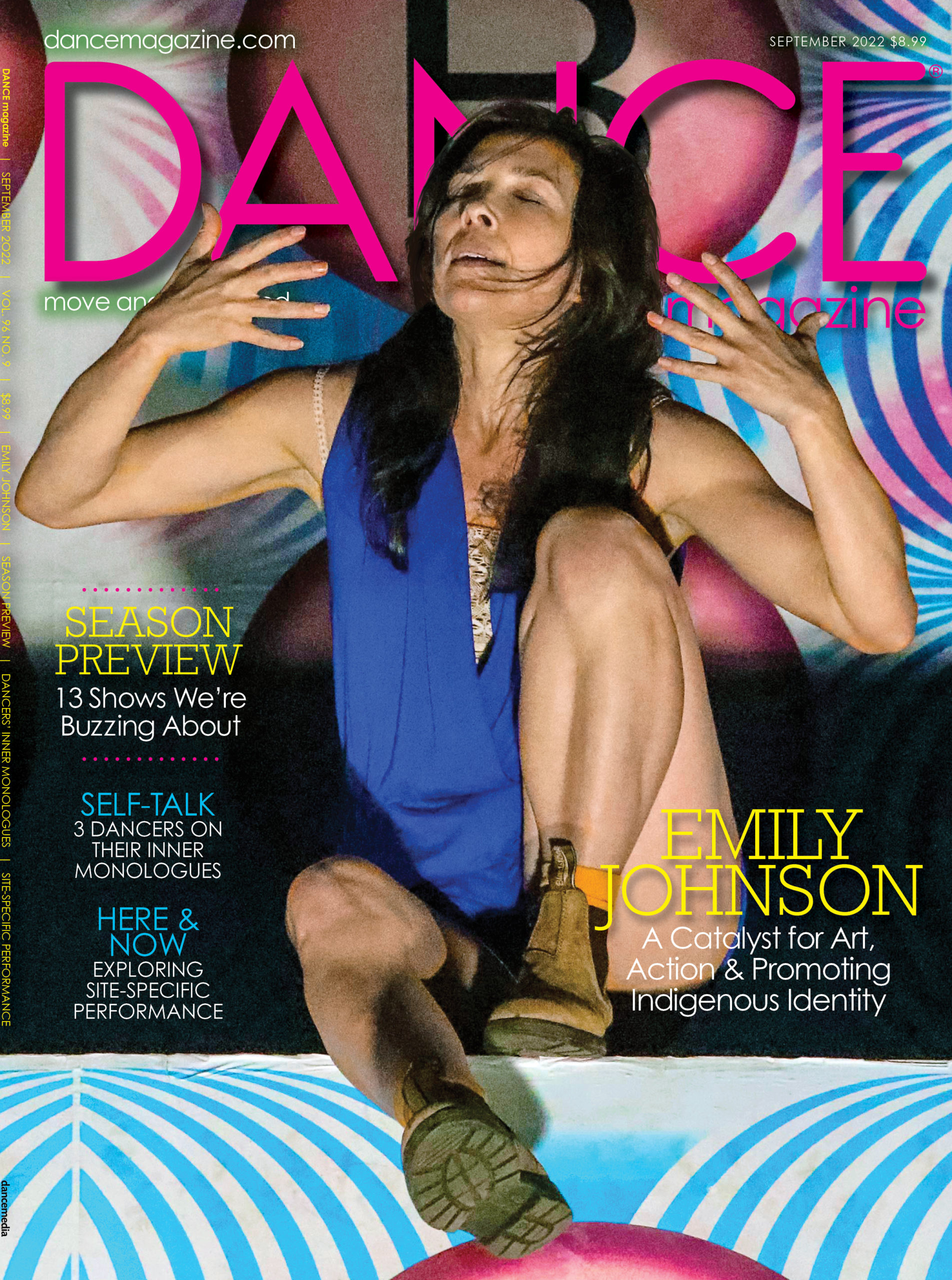 The cover of the September 2022 issue of Dance Magazine. Emily Johnson is seated, eyes closed and chine tips up as she brings splayed hands towards her face, dark hair loose around her shoulders. One knee is tucked up beneath her, foot planted, while the other is kicked out in front, dangling off a ledge. Around her, white and blue swirls and pink circles, pieces of an artwork we're too close to see fully.
