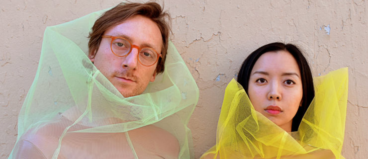 male and female staring at camera wearing mesh shirts