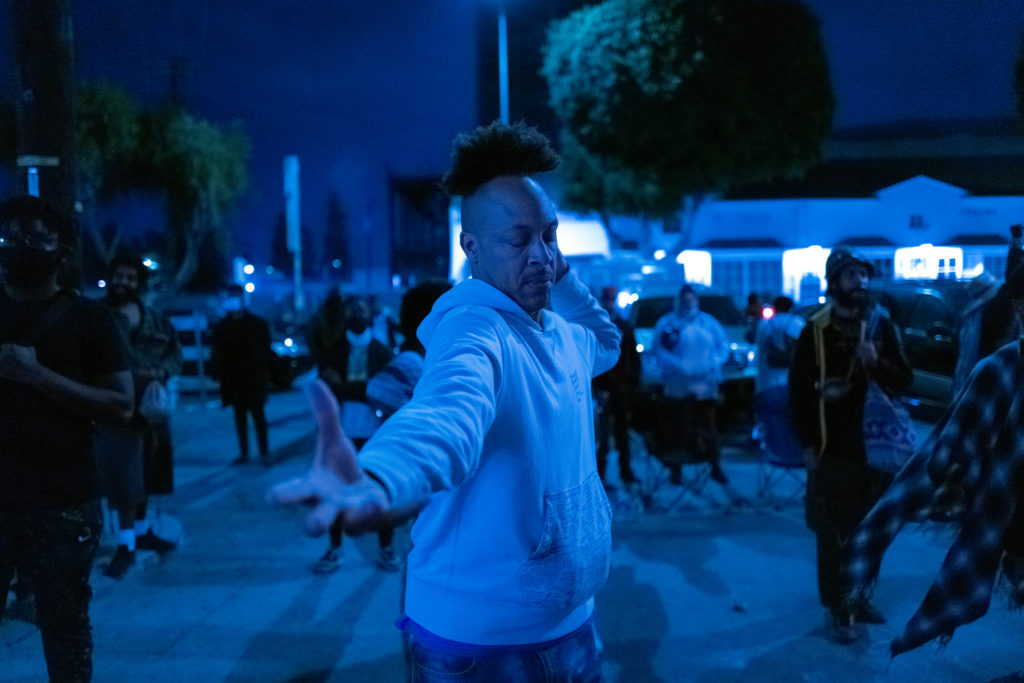 man wearing white sweatshirt dancing in group of people outside 