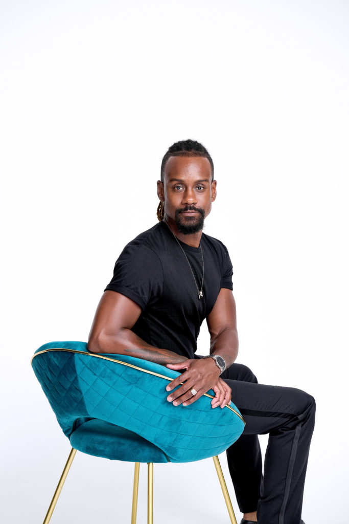 The Big Muddy Dance Company artistic director Kirven Douthit-Boyd sitting on a turquoise chair.