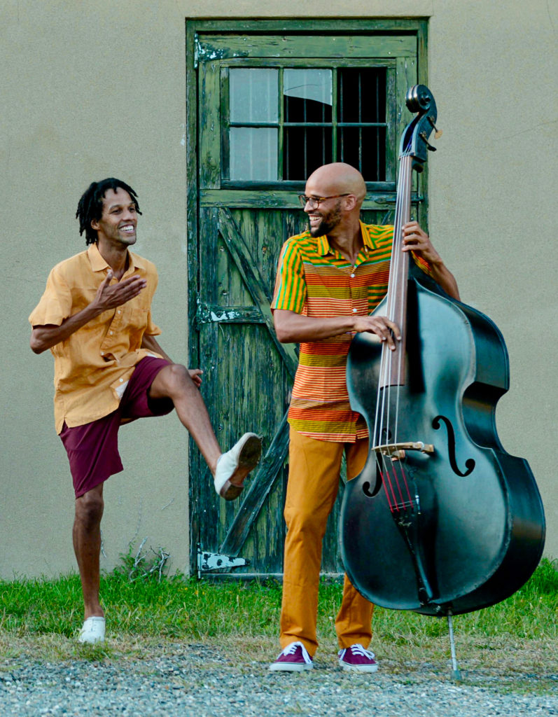 two males dancing and playing the bass 
