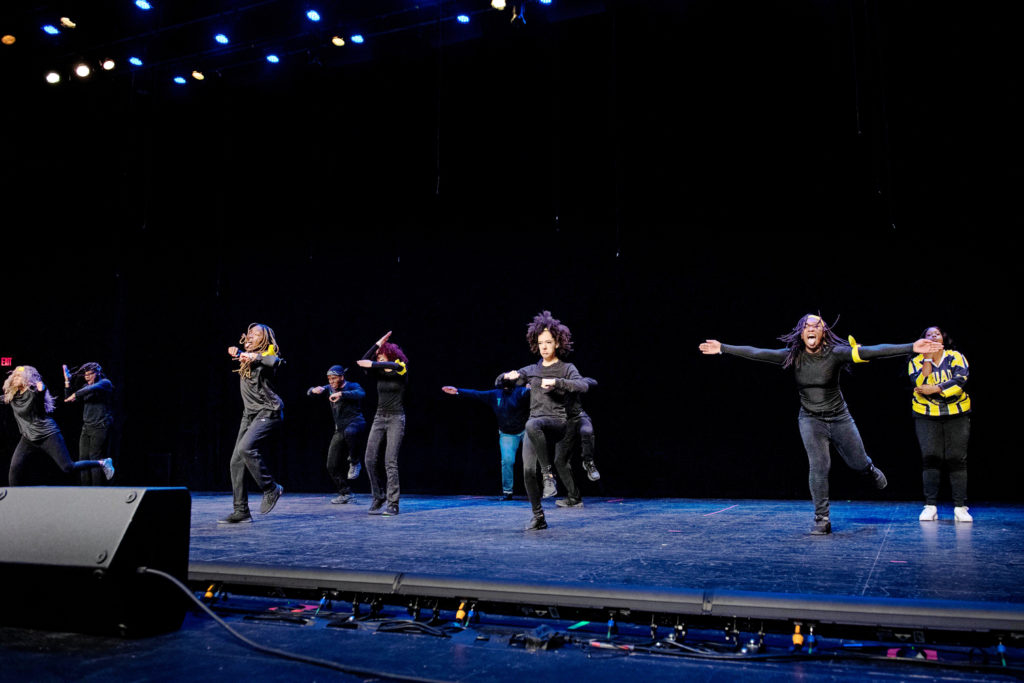 step dancers wearing all black performing on stage 