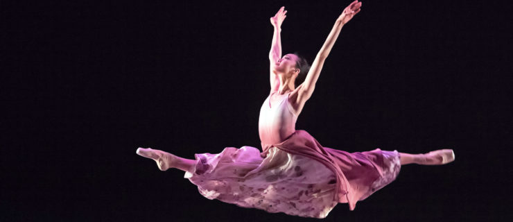 female dancer performing grand jete in long pink skirt