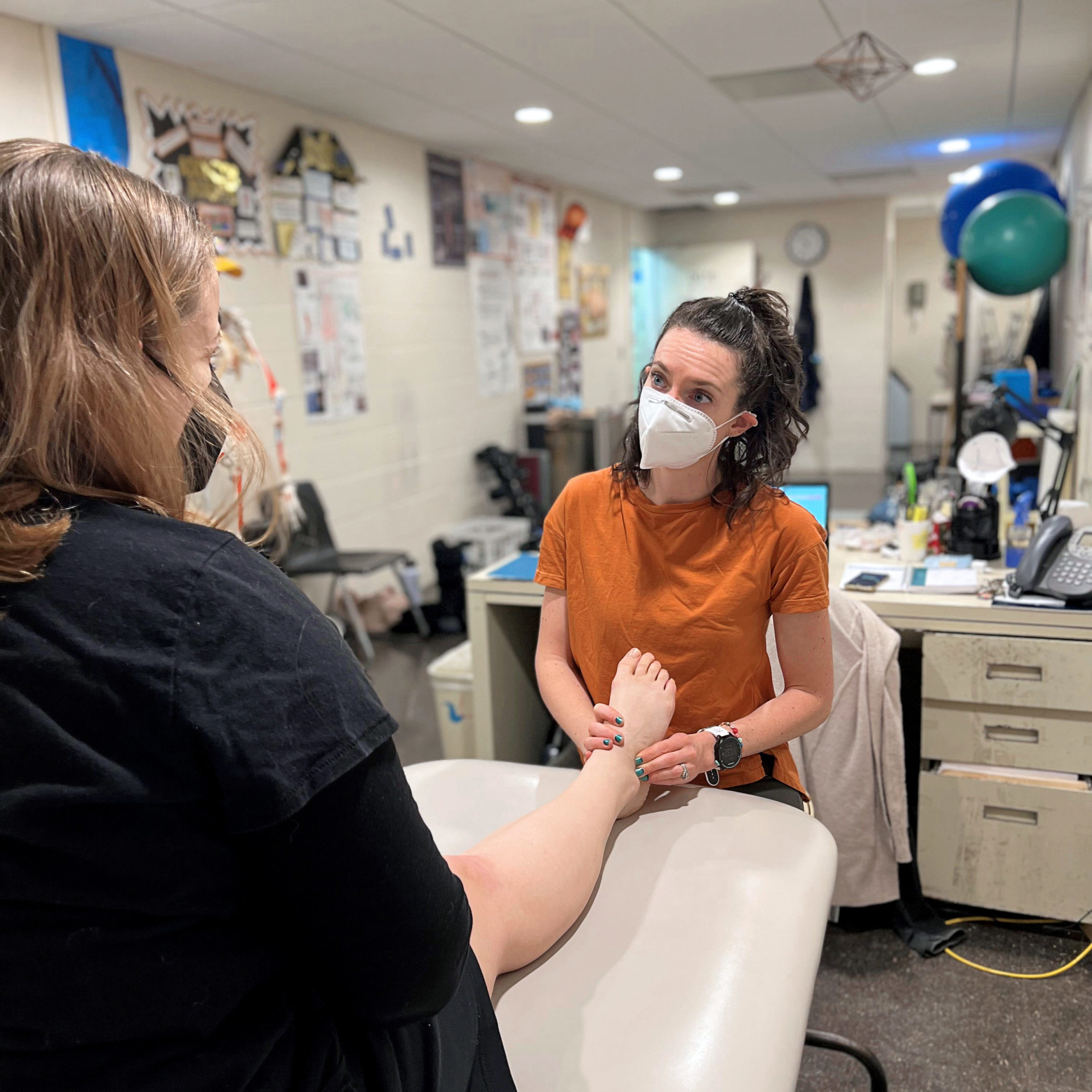 athletic trainer examining a dancer's foot 