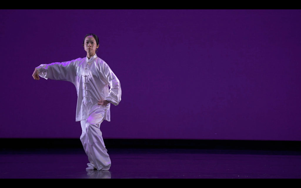 female dancer on stage wearing long white costume 