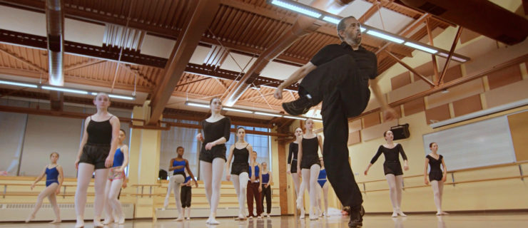 male instructor teaching a group of female dancers in a studio