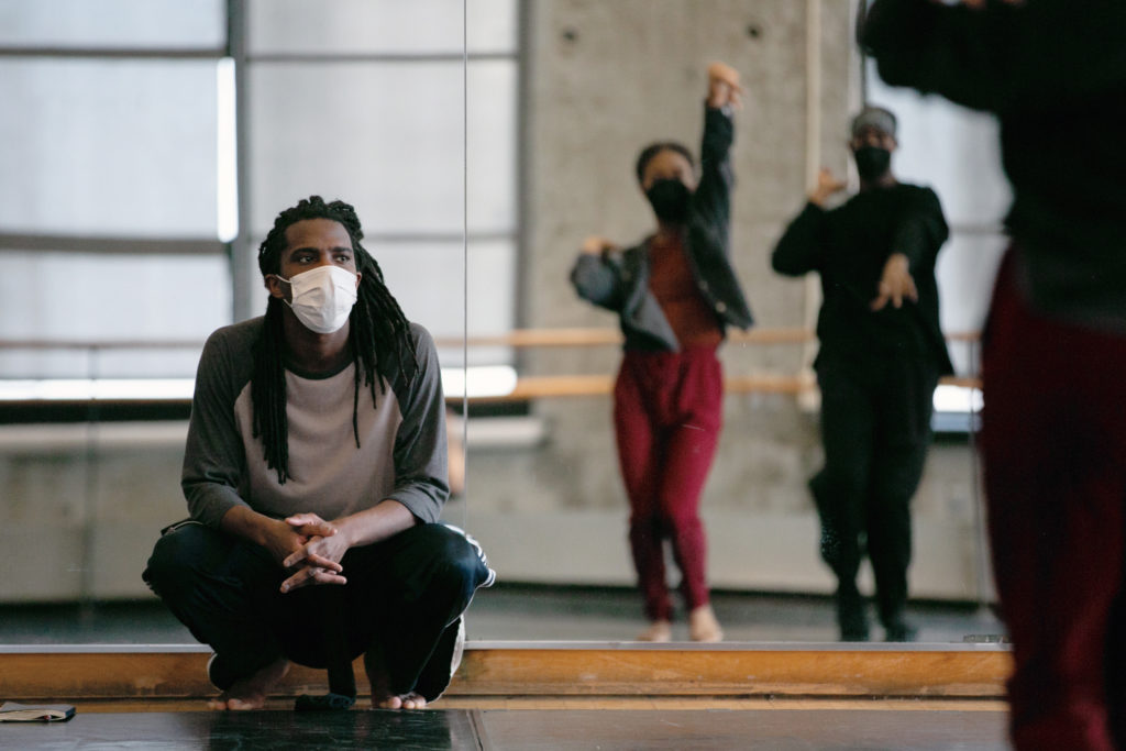 male teacher watching dancers in studio