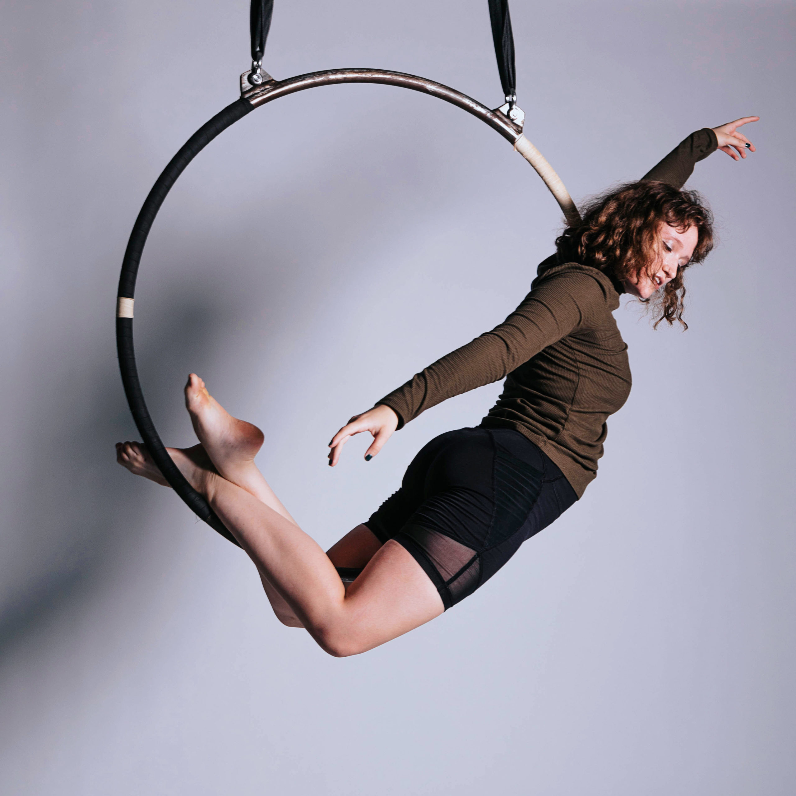 female dancer balancing on hanging hoop