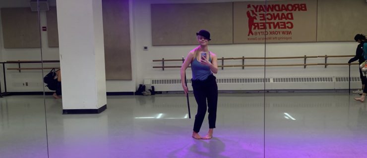Haley Hilton in a dance studio bathed in purple light strikes a jazz pose