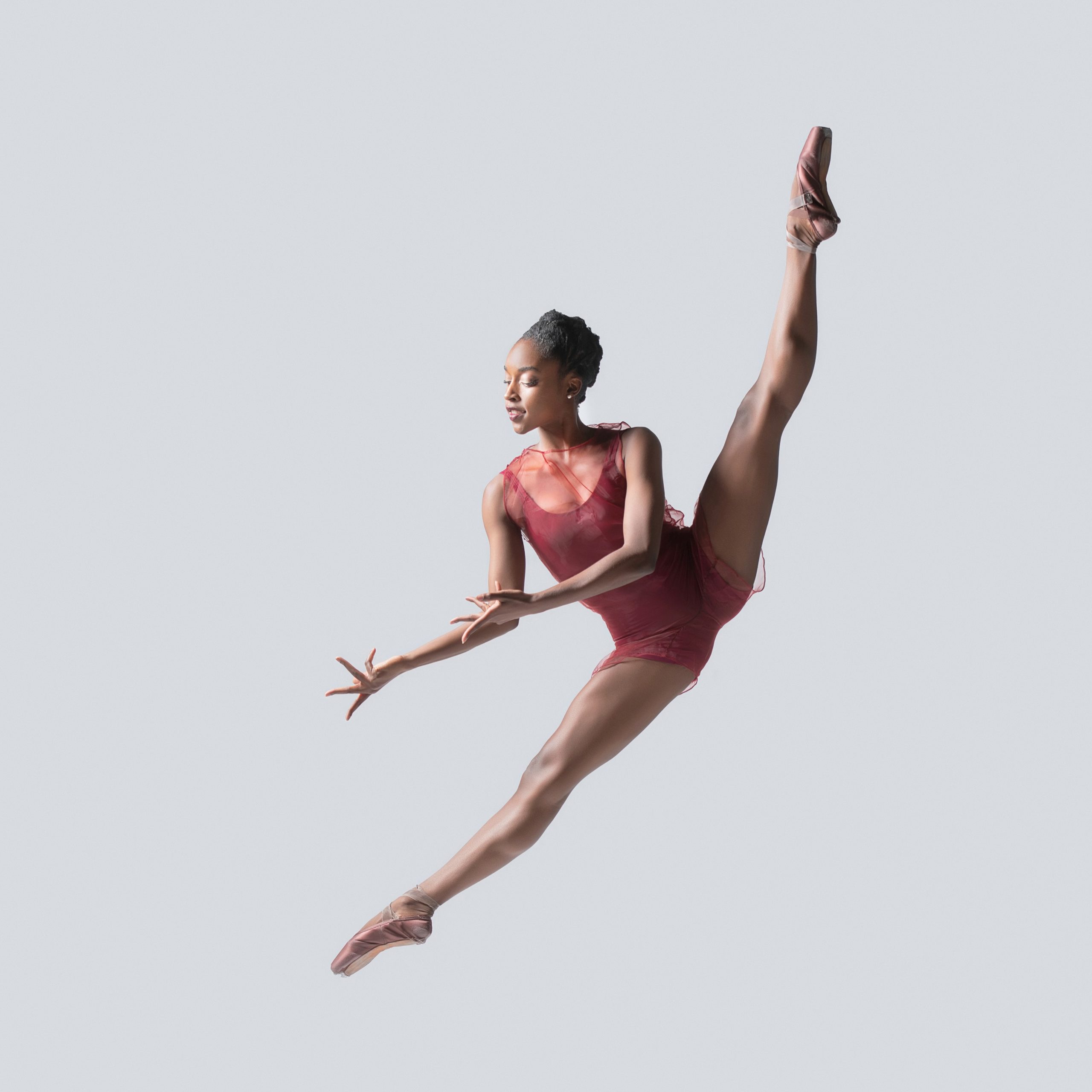 dancer in pink leotard performing tilt jump