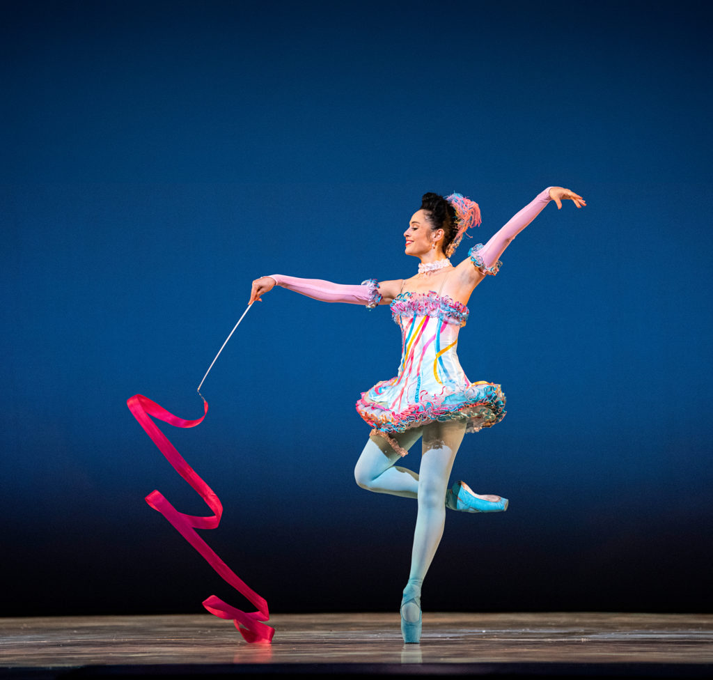 female dancer in colorful tutu with red ribbon