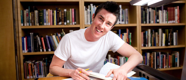 man holding a book and smiling