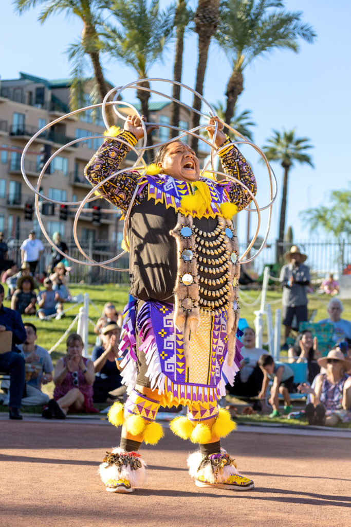 male dancer performing with hoops in a park