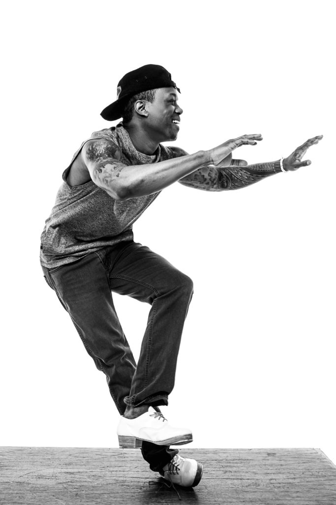 male tap dancer standing on the outer edge of his shoe