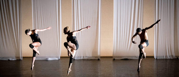 three dancer jumping in parallel passe with one arms swinging back