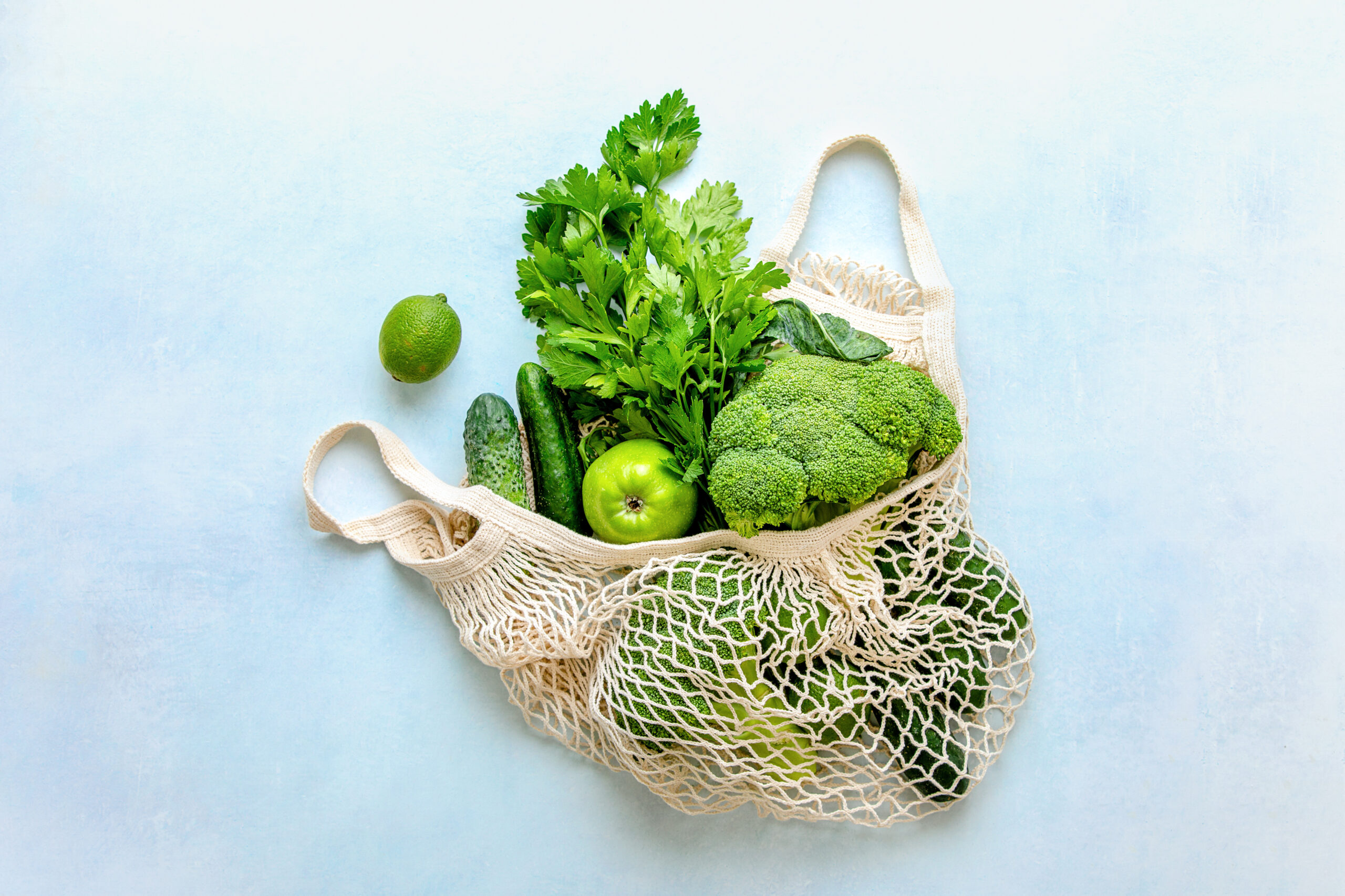 green fruits and vegetables in mesh bag