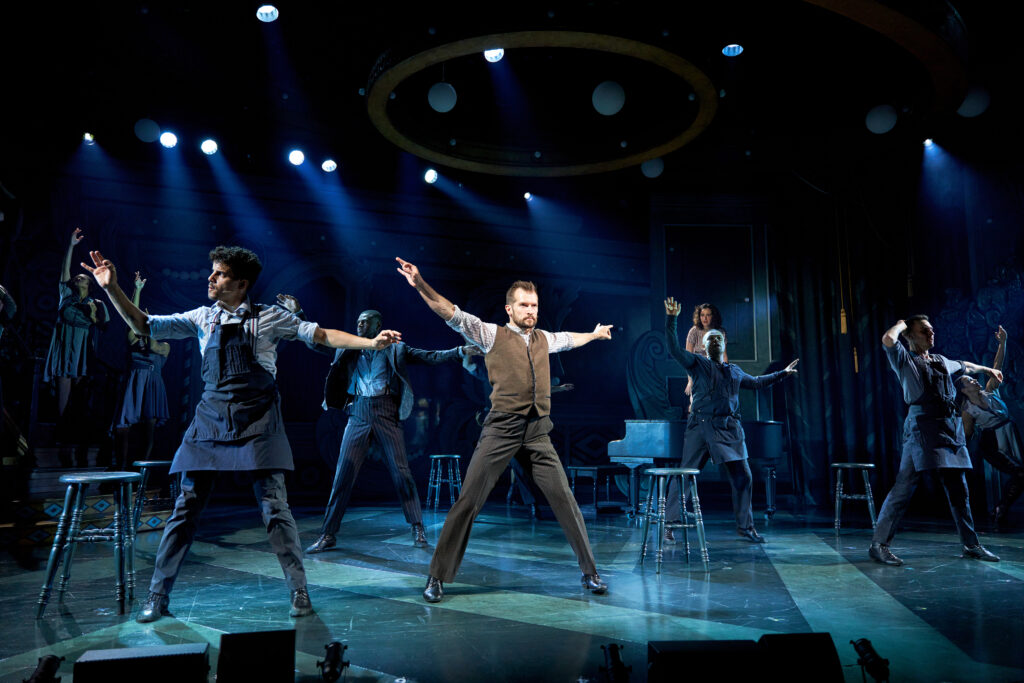 five male dancers with their arms outstretched side