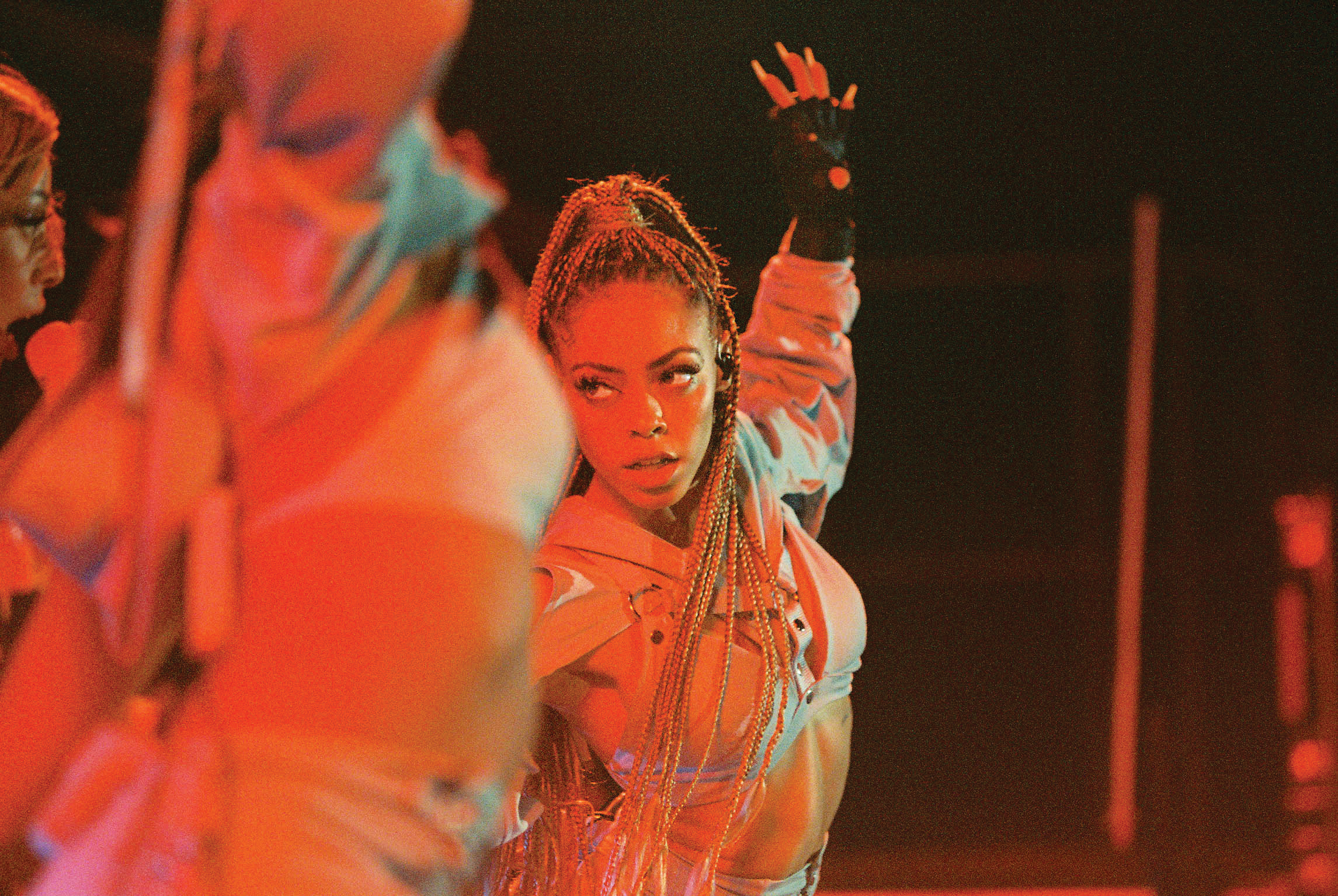 female dancer under red lights looking to the side