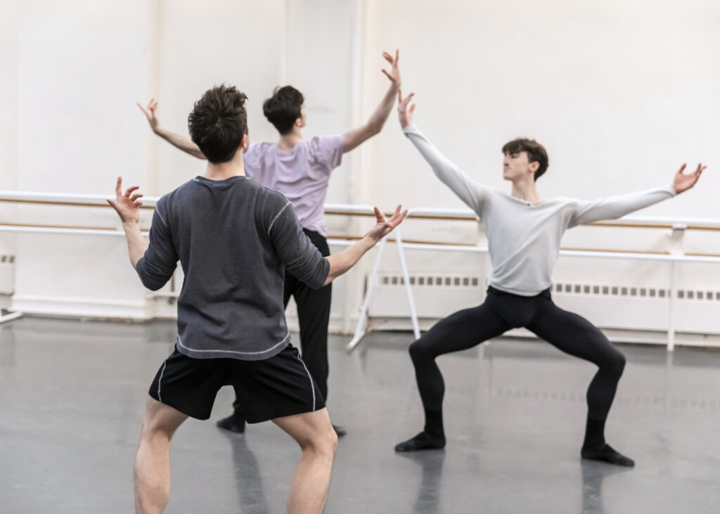 male choreographer directing two male dancers 