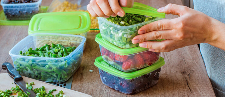 green reusable food containers with vegetables and fruits