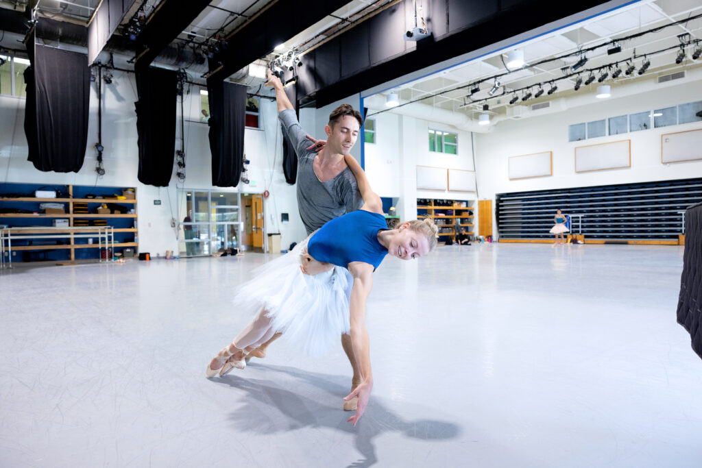 a male dancer holding a female dancer and she dips down towards the floor