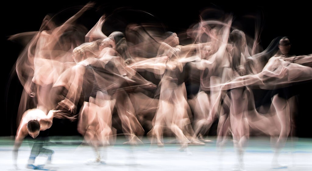 A blur of dancers in motion, appearing almost like ghosts.