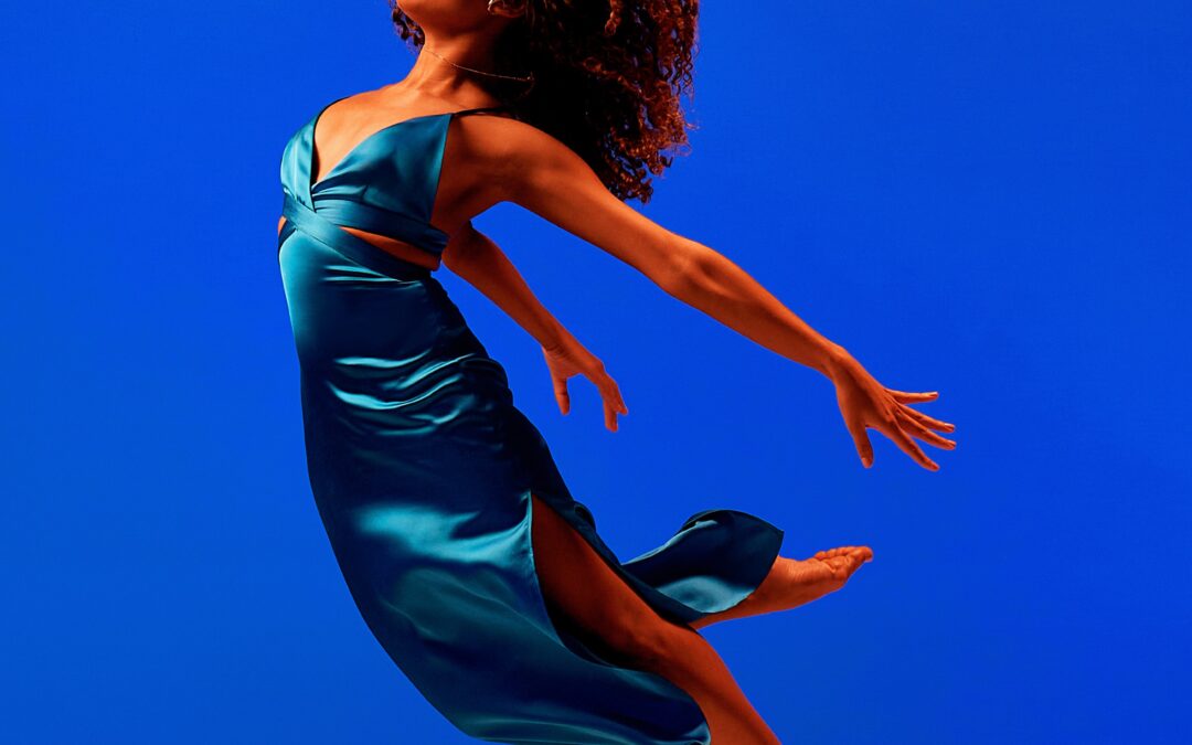 a female dancer mid air with her arms and legs extended behind