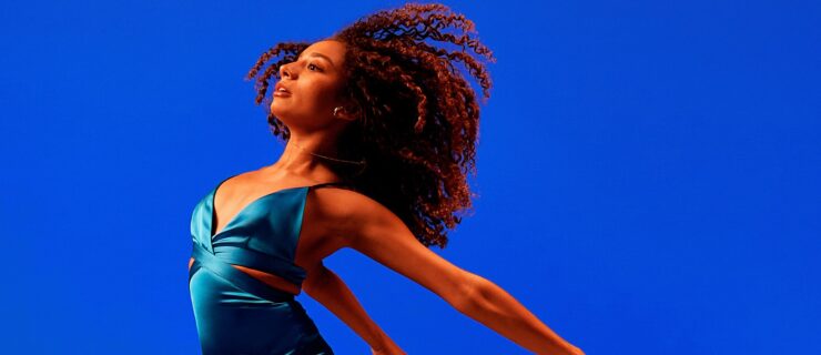 a female dancer mid air with her arms and legs extended behind
