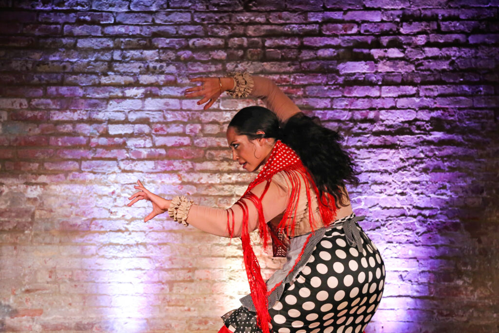a female dancer lunging side with her arms outstretched 
