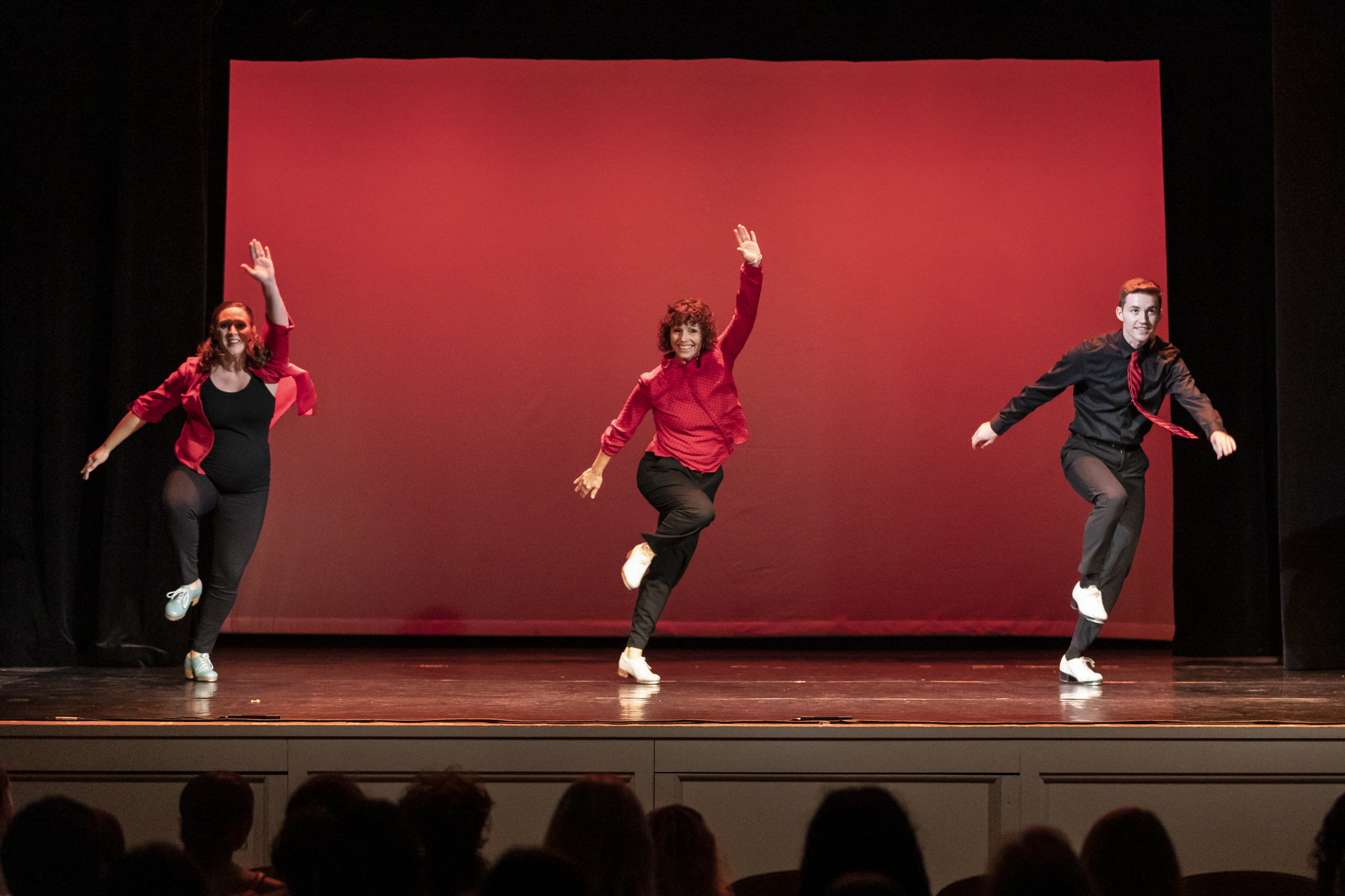 From left: Kelly Ging, Maria Majors, and Tommy Wasiuta of STL Collaborative perform a trio tap dance in black and red costumes.