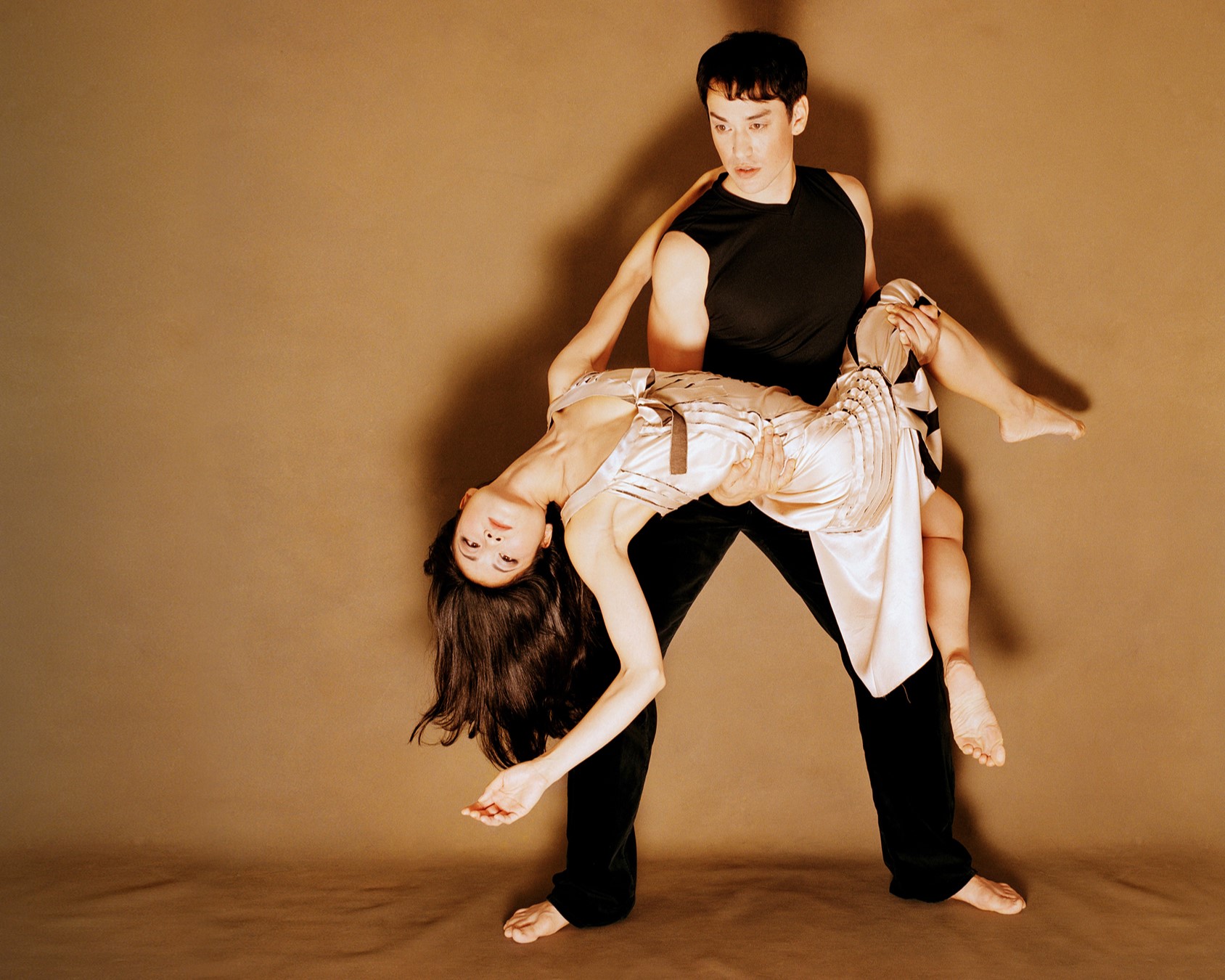 a male dancer holding a female dancer as she leans backwards