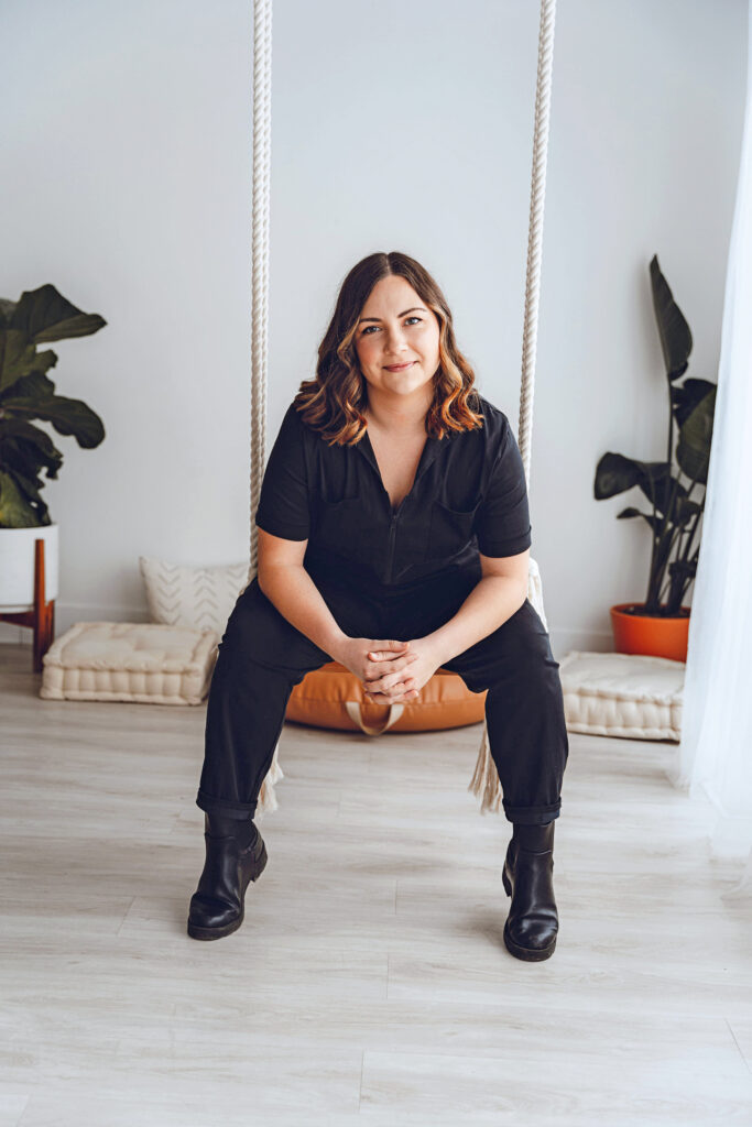 a woman sitting in a chair wearing all black 