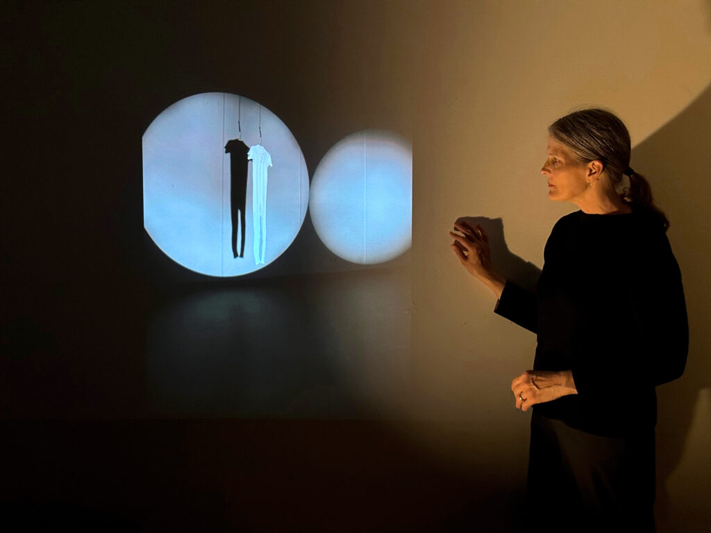 a female dancer staring at a circular projection on a wall