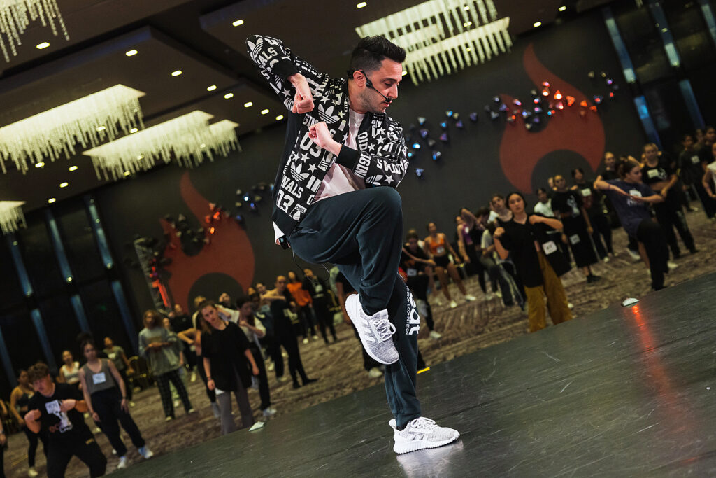 a dancer leading a hip hop combo on stage