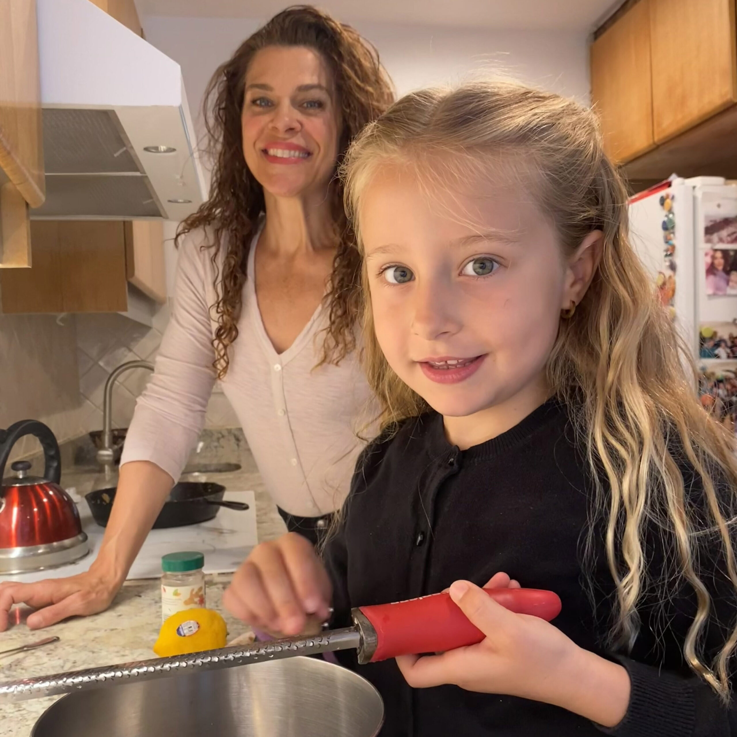 a young girl and mom cooking in the kitchen 
