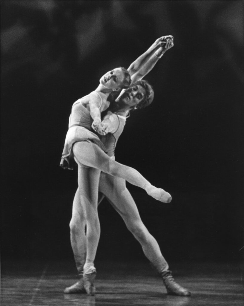 a female dancer in attitude derriere being supported from behind by a male dancer