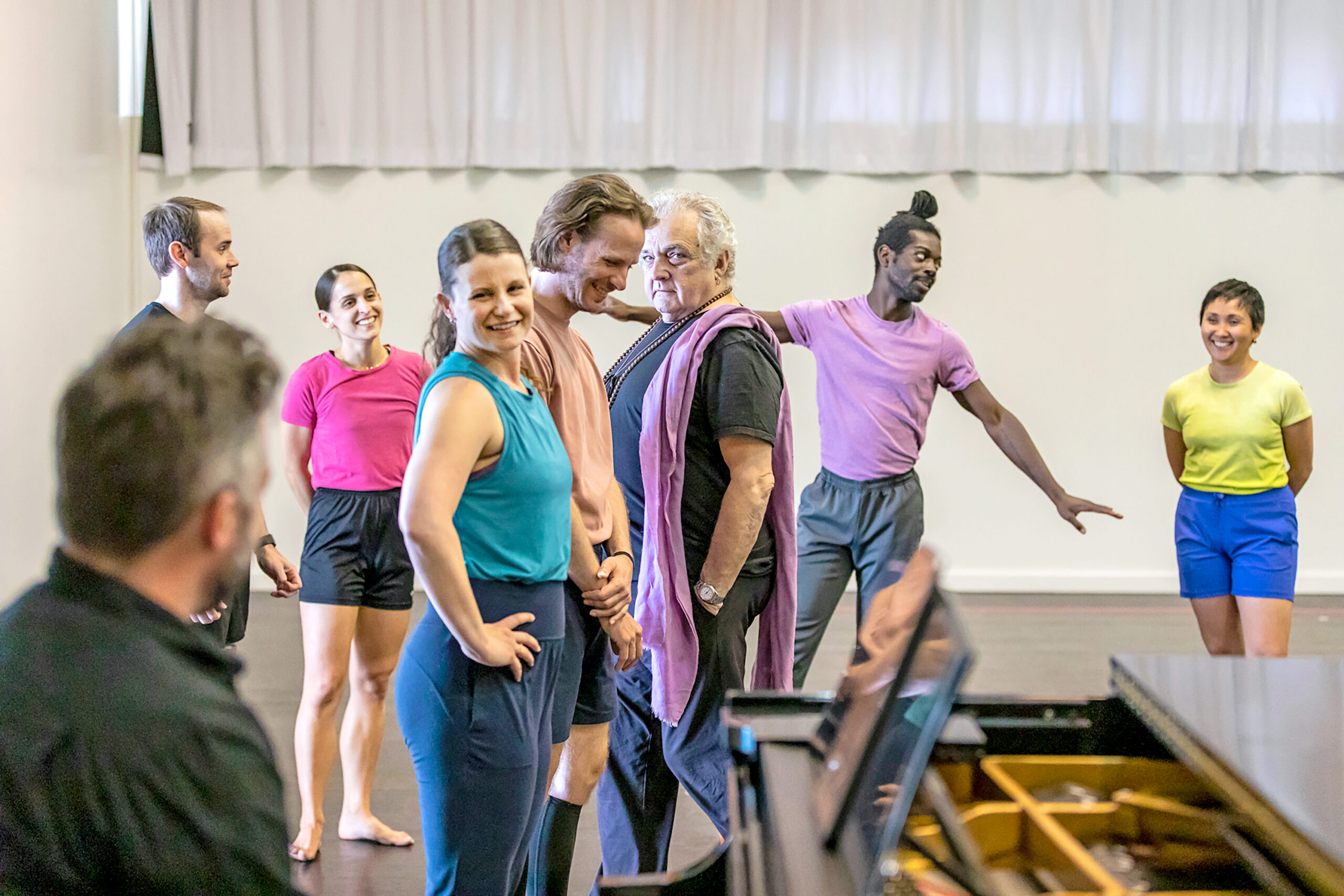 a group of dancers smiling while in rehearsal