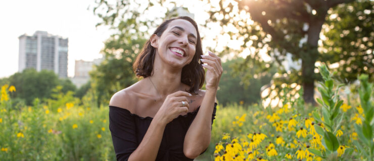 a female dancer laughing while standing by flowers