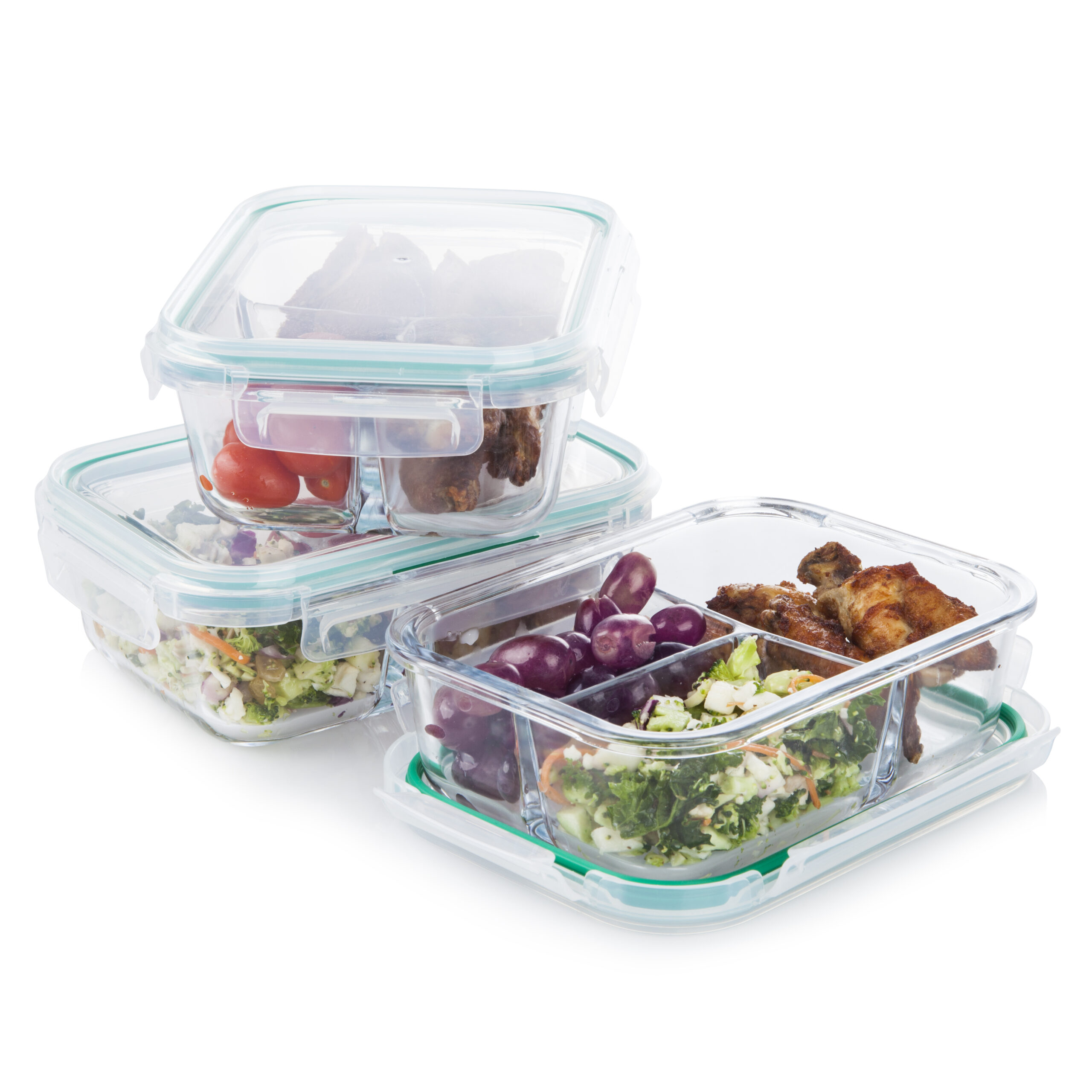 Clear glass food storage meal prepping containers with fresh berries, carrots, fruits, vegetables and meat on white background.